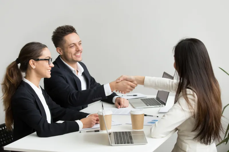 Friendly partners handshaking in a meeting